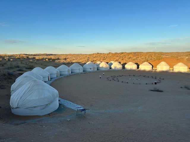 The circle of yurts at Sputnik Navoi in low evening sun