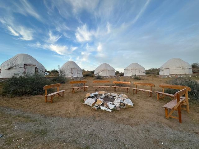 The camp fire pit ringed with benches under a wide desert sky